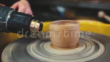 波特用工业烘干机烘干陶工`车轮上的粘土花瓶。 手工陶器里面。